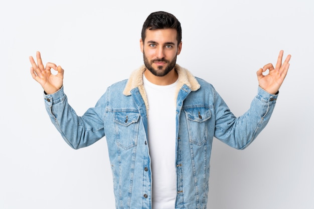 Jeune bel homme avec barbe isolé sur blanc dans une pose zen