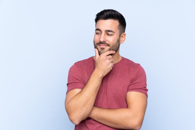 Jeune bel homme avec barbe isolé regardant sur le côté