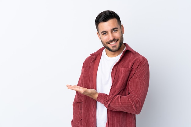 Jeune bel homme avec barbe portant une veste en velours côtelé isolé présentant une idée