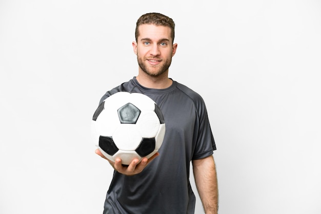 Jeune bel homme blond sur fond blanc isolé avec ballon de foot