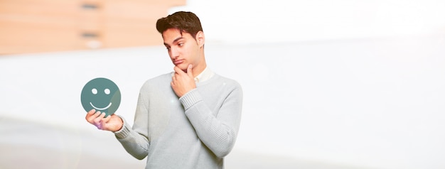 Jeune bel homme bronzé avec une émoticône smiley