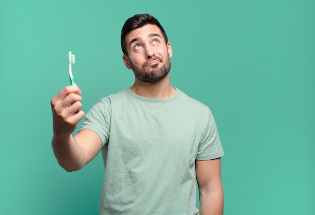 Jeune bel homme avec une brosse à dents.