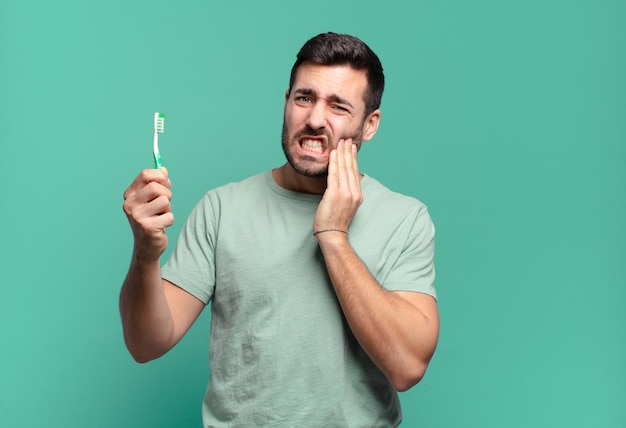 Jeune bel homme avec une brosse à dents.