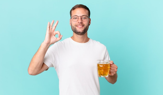 Jeune bel homme buvant une pinte de bière