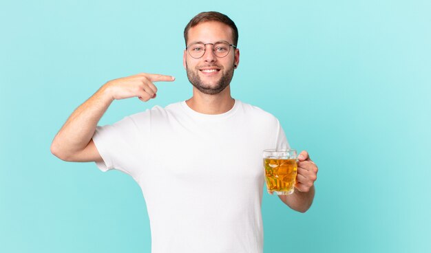 Jeune bel homme buvant une pinte de bière