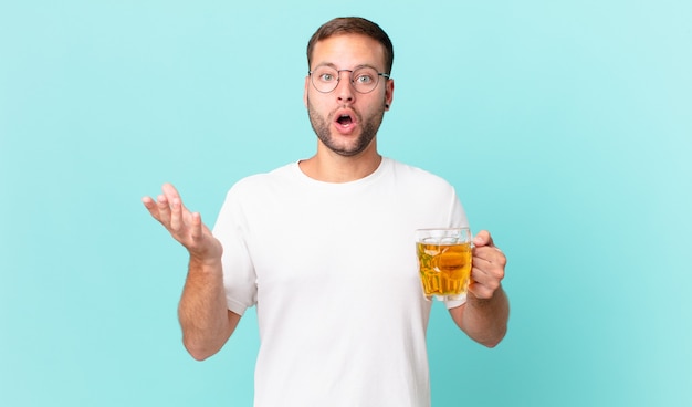 Jeune bel homme buvant une pinte de bière