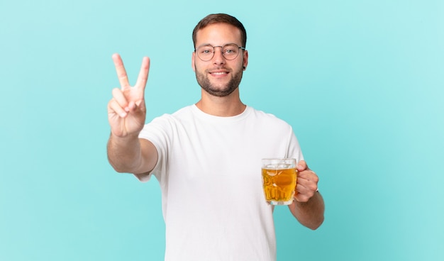 Jeune bel homme buvant une pinte de bière