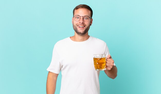 Jeune bel homme buvant une pinte de bière