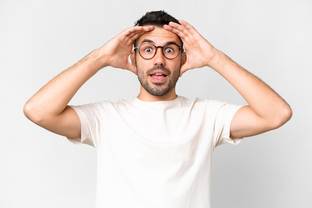 Jeune bel homme caucasien sur fond blanc isolé avec une expression de surprise