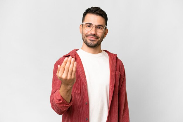 Jeune bel homme caucasien sur fond blanc isolé invitant à venir avec la main Heureux que vous soyez venu