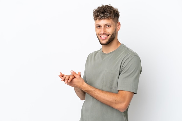 Jeune bel homme caucasien isolé sur fond blanc applaudissant