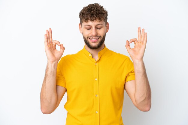 Jeune bel homme caucasien isolé sur fond blanc dans une pose zen