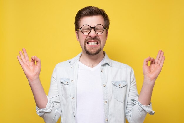 Jeune bel homme caucasien en méditation pose essayant de se détendre ou de se calmer