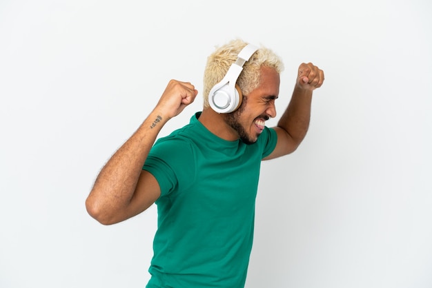 Jeune bel homme colombien isolé sur fond blanc, écouter de la musique et danser