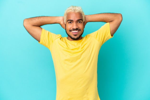 Jeune bel homme colombien isolé sur fond bleu en riant