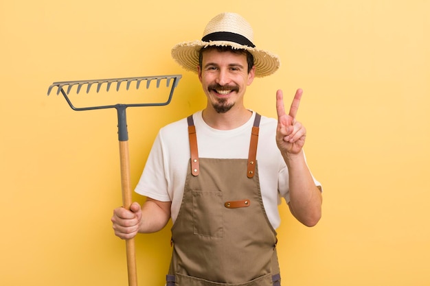 Jeune bel homme avec un concept de fermier de râteau