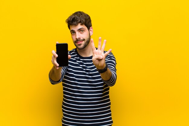 Jeune bel homme contre le mur orange