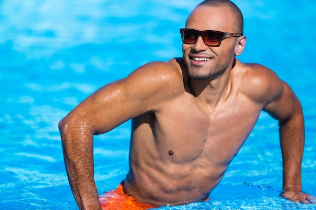 Jeune bel homme dans la piscine