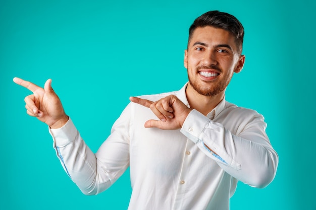 Jeune bel homme debout et pointant du doigt sur le côté