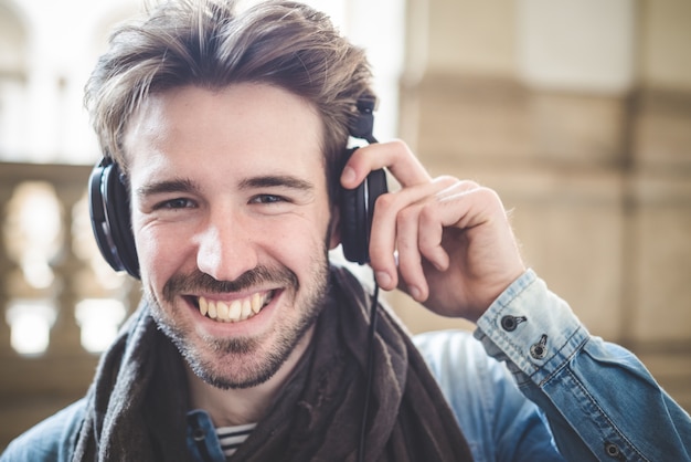 jeune bel homme, écouter de la musique avec des écouteurs