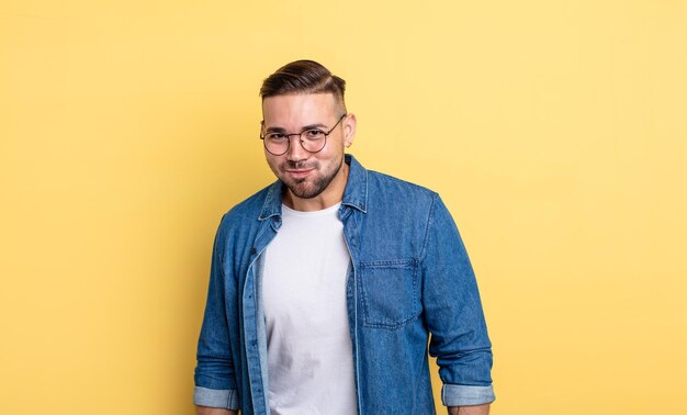 jeune bel homme avec une expression maladroite, folle et surprise, des joues gonflées, se sentant bourré, gras et plein de nourriture