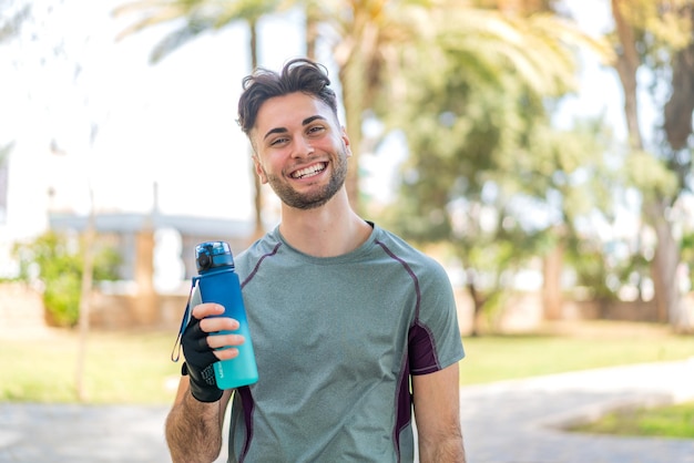 Jeune bel homme faisant du sport avec une bouteille d'eau