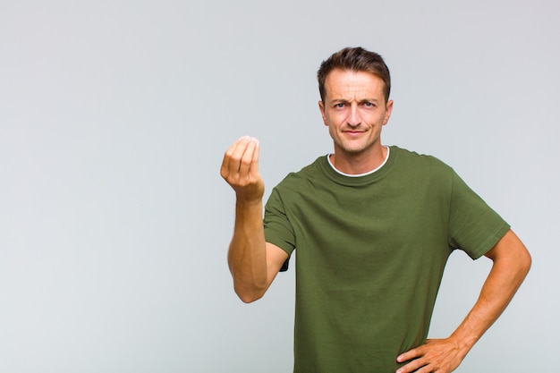 Jeune bel homme faisant le geste de l'argent