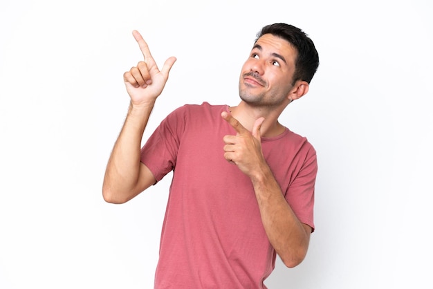 Jeune bel homme sur fond blanc isolé pointant avec l'index une excellente idée