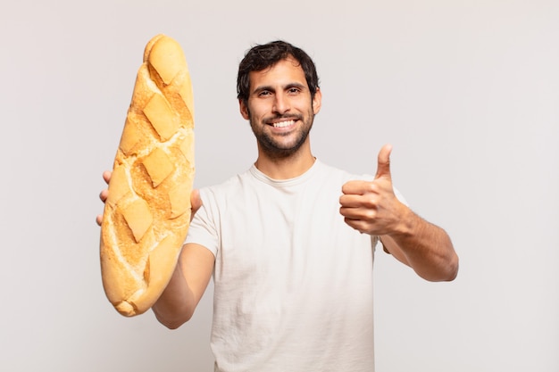 Jeune bel homme indien expression heureuse et tenant un pain