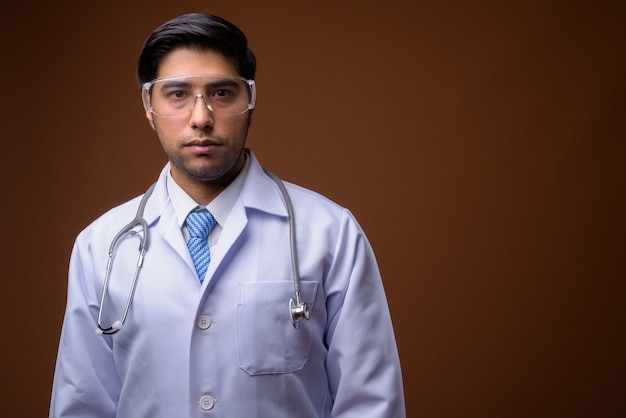 Jeune bel homme iranien médecin portant des lunettes de protection aga