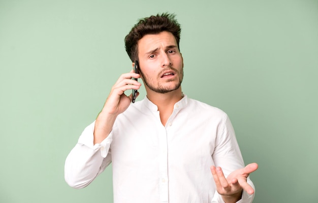 Jeune bel homme isolé à l'aide de son téléphone