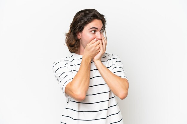 Jeune bel homme isolé sur fond blanc couvrant la bouche et regardant sur le côté