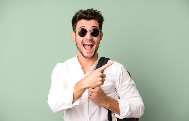 Jeune bel homme isolé avec un sac et des livres concept d'étudiant universitaire