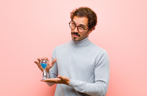 Jeune bel homme avec une minuterie de sable