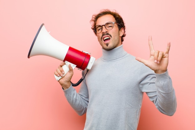 Jeune bel homme avec un mur plat de mégaphone rose