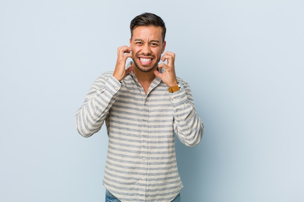 Jeune bel homme philippin bouleversé crier avec des mains tendues.