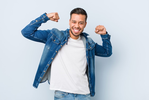 Jeune bel homme philippin montrant le geste de force avec les bras, symbole du pouvoir féminin