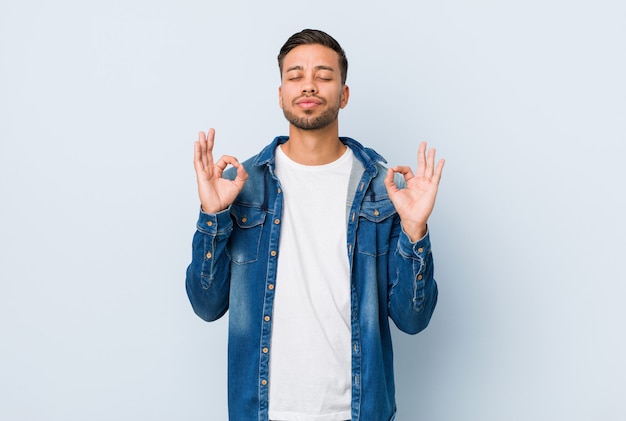 Jeune bel homme philippin se détend après une dure journée de travail, elle pratique le yoga.