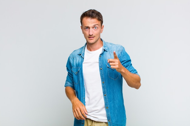 Jeune bel homme pointant avec une expression agressive en colère