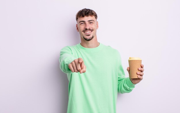 Jeune bel homme pointant vers la caméra en vous choisissant à emporter concept de café