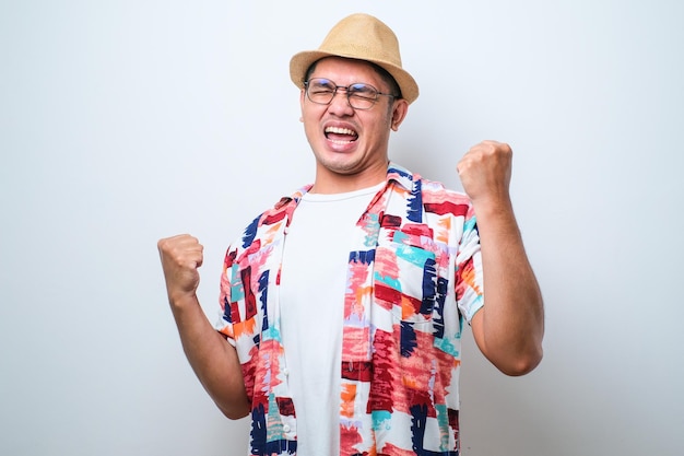 Jeune bel homme portant une chemise de plage décontractée debout très heureux et excité faisant le geste du gagnant avec les bras levés