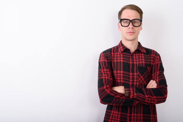 Jeune bel homme portant des lunettes sur un mur blanc