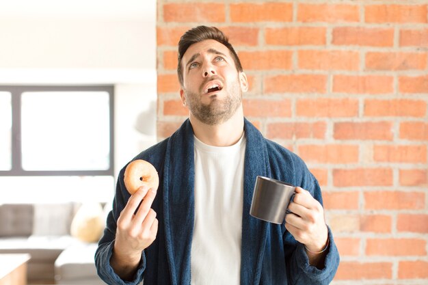 Jeune bel homme prenant un café à la maison