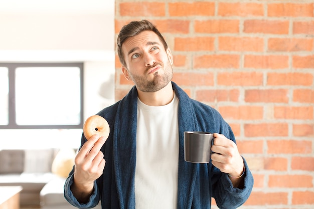 Jeune bel homme prenant un café à la maison