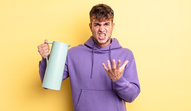 Jeune bel homme à la recherche de colère, agacé et frustré. concept thermos