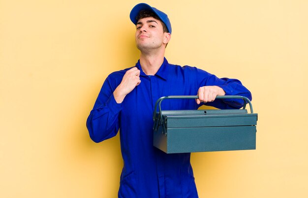 Jeune bel homme à la recherche d'un concept de plombier positif et fier arrogant