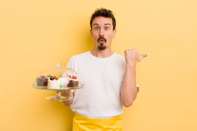 Jeune bel homme à la recherche d'étonnement dans l'incrédulité concept de gâteaux faits maison