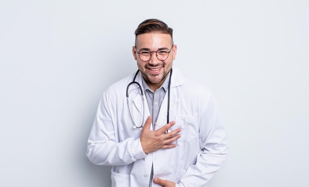 Jeune bel homme riant aux éclats d'une blague hilarante. concept de médecin