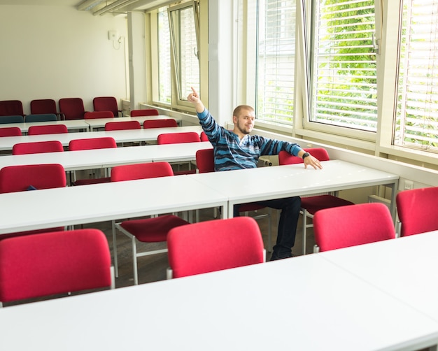 Jeune bel homme en salle de classe