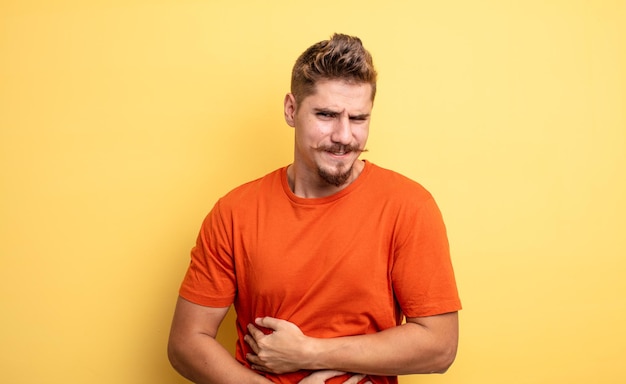 Jeune bel homme se sentant anxieux malade malade et malheureux souffrant d'un mal de ventre douloureux ou d'une grippe étrange concept de moustache